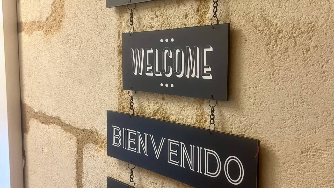 Auberge du porche à Blaye, hôtel trois étoiles en gironde en France, panneau de bienvenue dans l'entrée, accueil en français, en anglais, en allemand, en espagnol